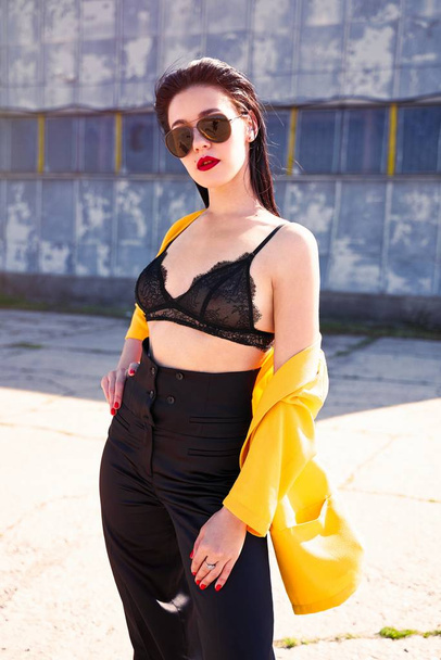 Young beautiful woman in plack lacy bra on the street  - 写真・画像