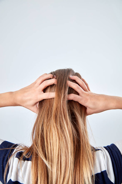 Νεαρή γυναίκα με πονοκέφαλο/πόνο κρατώντας το κεφάλι. - Φωτογραφία, εικόνα