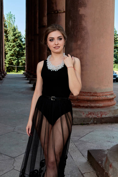 Η νεαρή γυναίκα φοράει ένα σέξι διαφανές μαύρο φόρεμα. Νέα γυναίκα μοντέρνο πορτρέτο. - Φωτογραφία, εικόνα