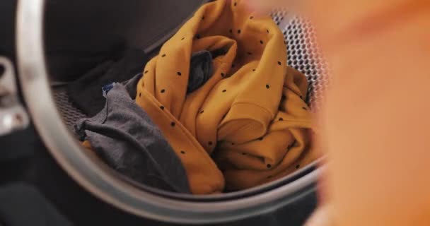 Womans hands loading clothes to washing machine. Self-service public laundry. - Metraje, vídeo