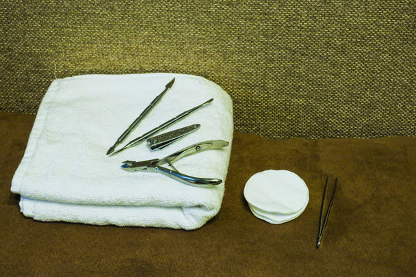 Εργαλεία μανικιούρ σε μια λευκή πετσέτα. Ψαλίδι, Λίμα νυχιών, ραβδιά, κλπ. - Φωτογραφία, εικόνα