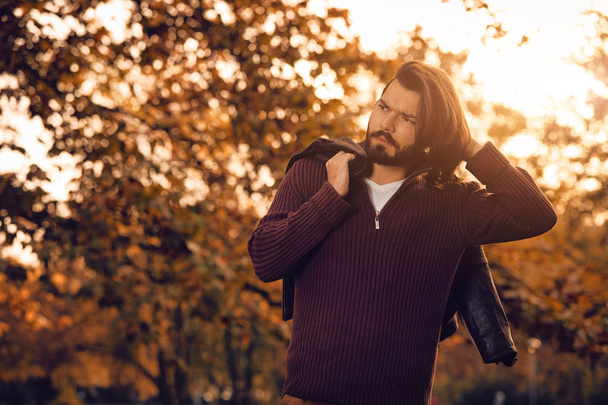Pohledný mladý muž nosí koženou bundu v podzimní sezóně / studené počasí. - Fotografie, Obrázek