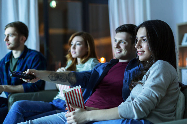 friends with popcorn watching tv at home - Zdjęcie, obraz