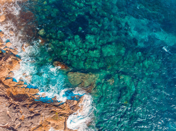 Costa de la isla desierta con el agua azul turquesa late en el arrecife rocoso. Vista superior aérea
. - Foto, imagen