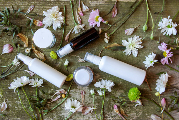 recipiente cosmético frasco spray dispensador flores verdes branco velho fundo de madeira país lado
 - Foto, Imagem