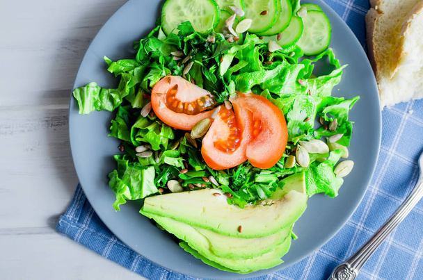 green salad of lettuce, cucumber, avocado and tomatoes - Photo, Image
