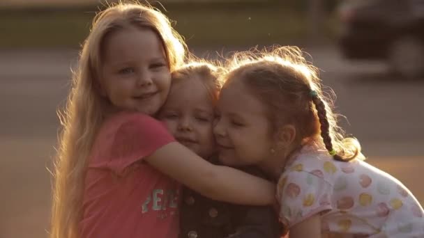 Schattige kleine meisjes knuffelen in het zonlicht. - Video