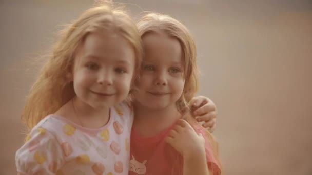 Adorable little girls hugging in sunlight. - Footage, Video