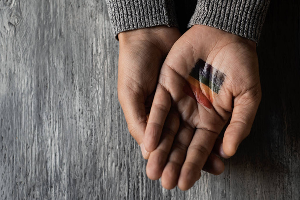 person with a rainbow flag in his or her hand - Foto, Imagen