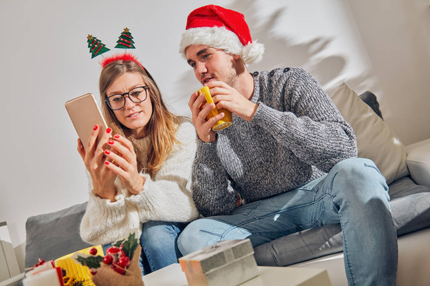 Boldog pár élvezi újév/karácsony előestéjén a mobiltelefon  - Fotó, kép