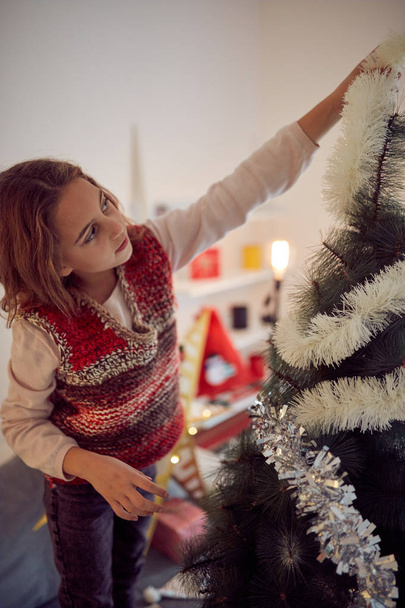Child girl preparing shiny decoration for Christmas / New Year's - Photo, Image