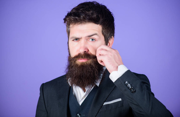 Man bearded hipster wear classic suit outfit. Formal outfit. Elegancy and male style. Fashion concept. Guy wear formal outfit. Impeccable style. Businessman fashionable outfit stand violet background - Fotografie, Obrázek