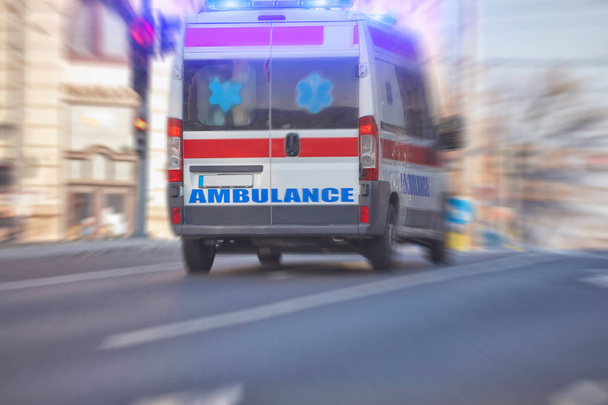 Ensihoitaja 911 ambulanssi auto kulkee nopeasti suurkaupungin läpi. - Valokuva, kuva