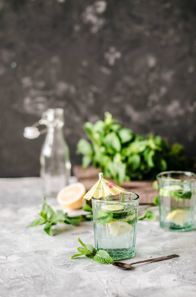 Healthy water with cucumber, lemon and mint on the concrete background. - Fotó, kép