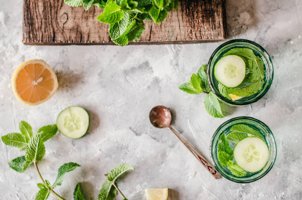 Healthy water with cucumber, lemon and mint on the concrete background. - Fotoğraf, Görsel