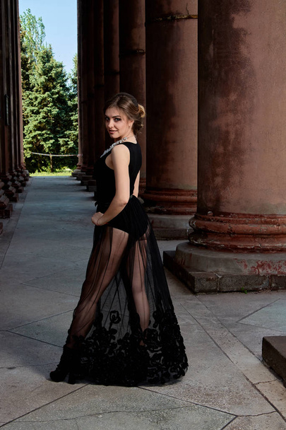 Jonge vrouw draagt een sexy transparante zwarte jurk. Jonge vrouw modern portret. - Foto, afbeelding
