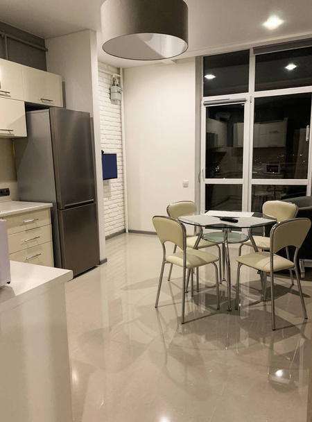 Modern, világos belső konyha, fehér bútorokkal és étkezőasztallal - Fotó, kép