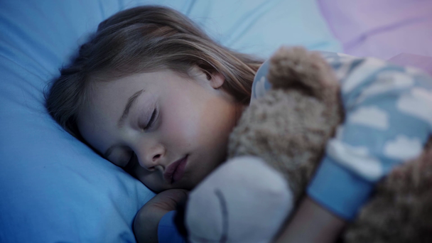 cute kid with teddy bear closing eyes and falling asleep while light turning off - Footage, Video