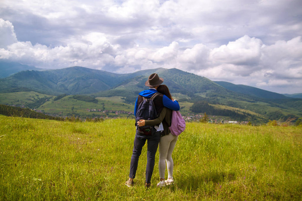 Rear view of hiking couple hugging and laughing on top of mountain. - Photo, Image