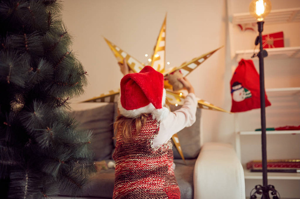 Çocuk kız Noel/yeni yıl için parlak dekorasyon hazırlanıyor - Fotoğraf, Görsel