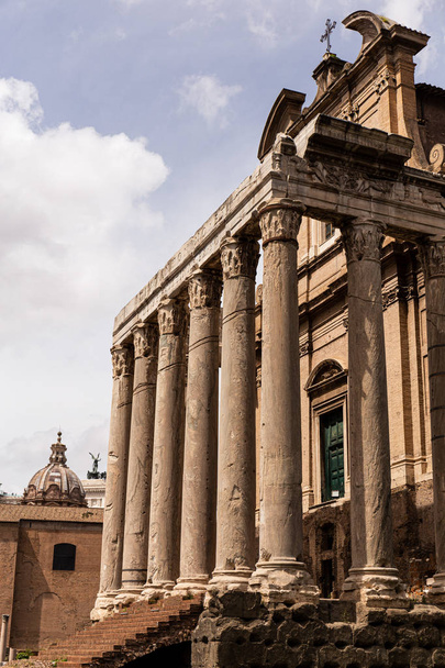 ROME, ITALY - JUNE 28, 2019: temple of Antoninus and Faustina under blue sky - Fotó, kép