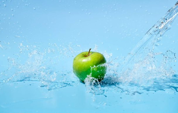 Green apples in clear water splash on blue background - Фото, зображення
