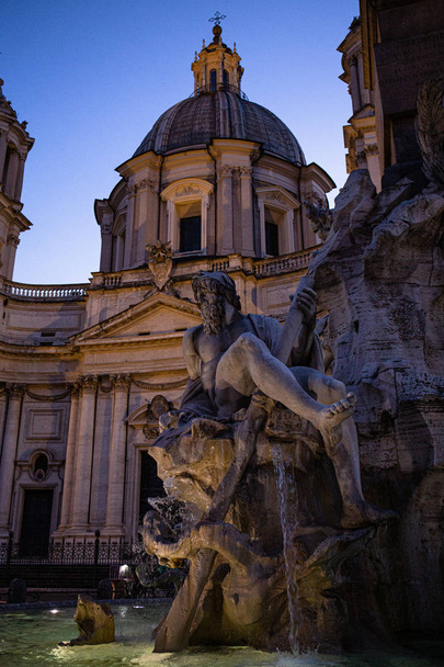 Roma, İtalya - 28 Haziran 2019: Gökyüzünün altındaki eski binanın yakınında antik Roma heykelleriyle çeşme  - Fotoğraf, Görsel