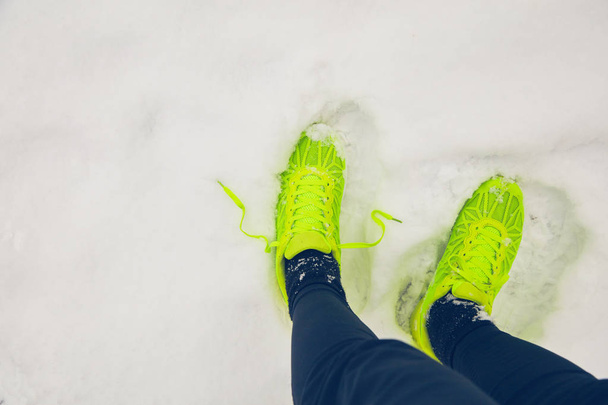 Szczegóły człowieka nogi jogging w parku w snowy czas. - Zdjęcie, obraz