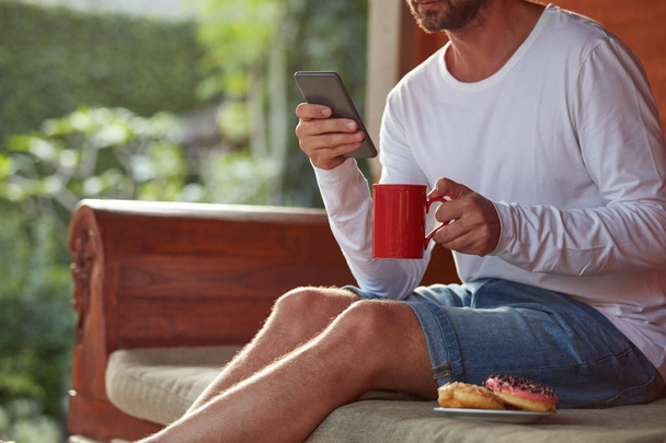 Člověk sedící na terase a pití kávy/čaje, jídlo - Fotografie, Obrázek