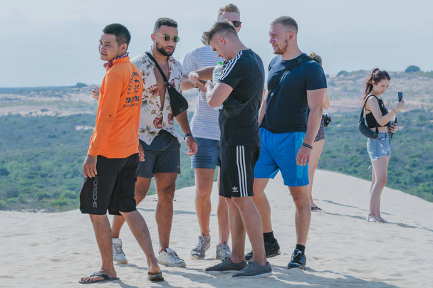 MUI NE, VIETNAM - 25 de abril: Turistas não identificados relaxam e tiram fotos em 25 de abril de 2019 no deserto de dunas de areia branca
 - Foto, Imagem