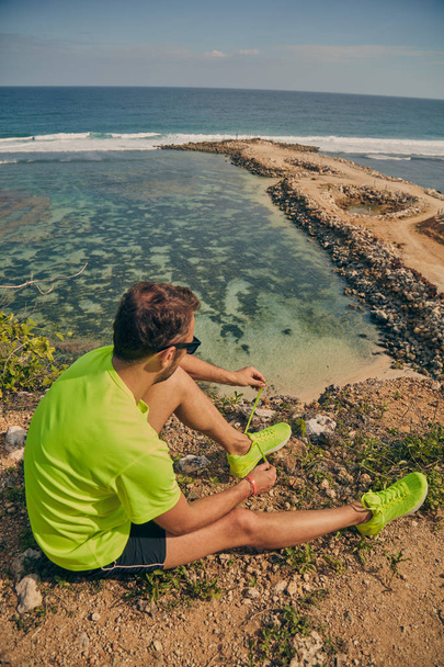 Sportsman wiązanie jogging bieganie trampki nad oceanem plaży o - Zdjęcie, obraz
