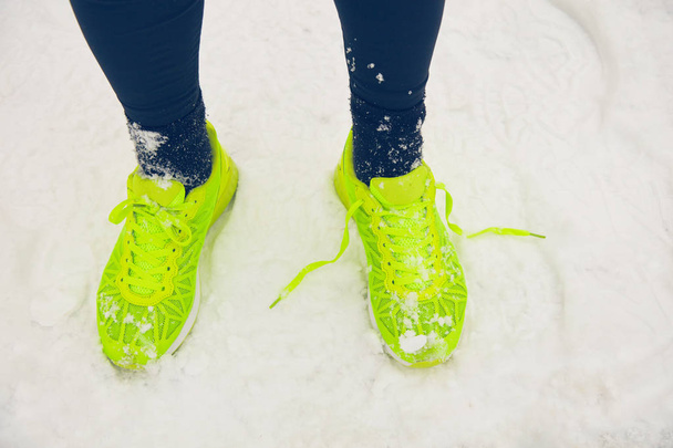 Detalle de las piernas del hombre corriendo en el parque en el momento nevado
. - Foto, Imagen