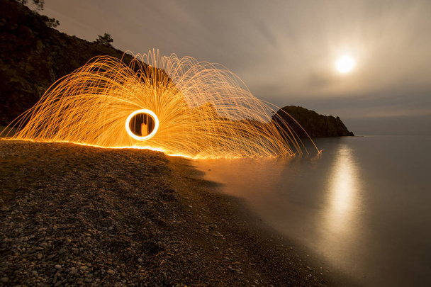 Taking pictures of steel wool by the naked sea - Photo, Image