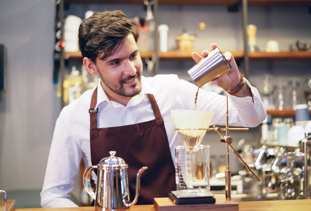 Barista junger Mann, der Kaffee in Tropfkaffee gießt. profes - Foto, Bild
