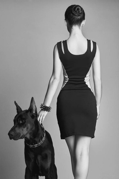 Girl with Doberman. Beautiful young woman with Dog - Zdjęcie, obraz