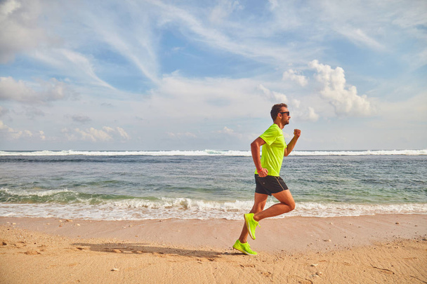 Man Running/joggen op een tropisch exotisch strand. - Foto, afbeelding