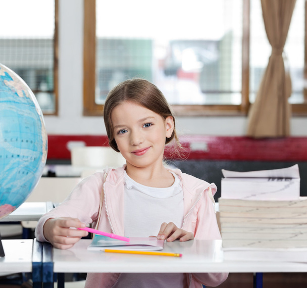 Cute Girl Smiling With Books And Globe At Desk - Foto, Imagen