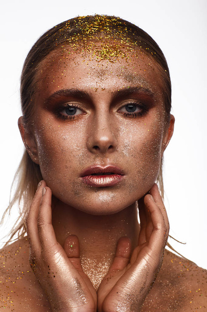 Portrait of a beautiful woman with expressive creative make-up in bronze. Studio beauty photo session - Фото, зображення