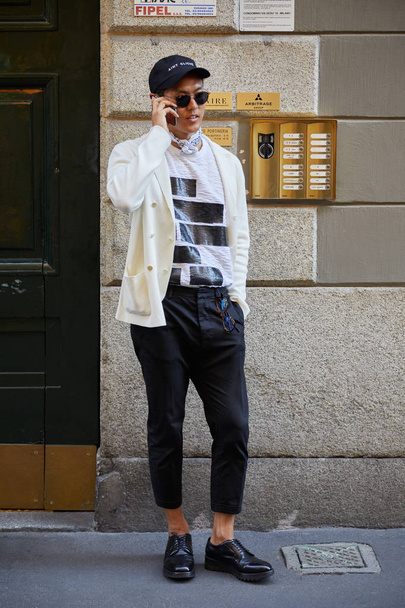 Man with black and white clothings calling with phone before Versace fashion show, Milan Fashion Week street style on June 17, 2017 in Milan. - Fotografie, Obrázek