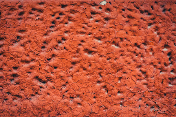 Kant van het gebouw is rood geschilderd. Gedetailleerde onvolmaakte textuur van belualde schuim blok met gaten close-up. Achtergrond van de constructie van geschuimd materiaal in macro met Kopieer ruimte. Decoratief uitzicht. - Foto, afbeelding