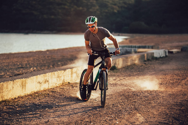 Man ride mountain bike on the beach. Sport and active life conce - Photo, Image