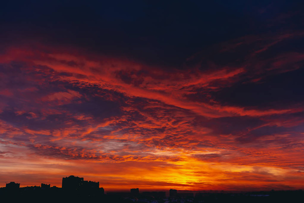 Fiery red blood vampire dawn. Amazing warm dramatic fire blue dark cloudy sky. Orange sunlight. Atmospheric background of sunrise in overcast weather. Hard cloudiness. Storm clouds warning. Copy space - Photo, Image