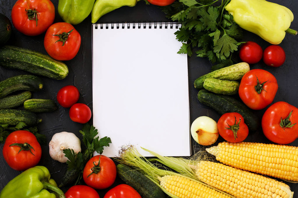 夏野菜:トマト、キュウリ、トウモロコシ、パセリ、ピーマン、玉ねぎ、ニンニク、ズッキーニは暗い背景に位置しています, トップビュー - 写真・画像