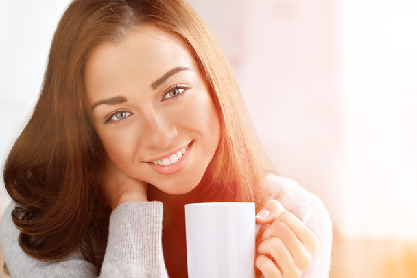 Приваблива жінка п'є каву вдома
 - Фото, зображення