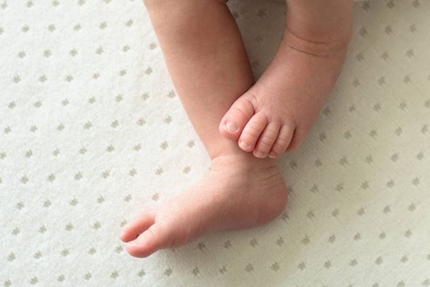 πόδια του νεογέννητου μωρού σε λευκό φόντο, δάχτυλα στο πόδι, γλυκές άκρες,  - Φωτογραφία, εικόνα