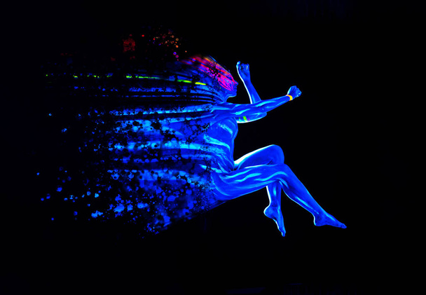 Ultraviolet black light glowing bodyart on young womans body. Dispersing girl on black background. Art creative concept - Photo, Image