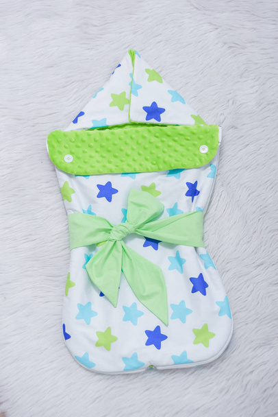 Tahliye için paket zarf. Bebek karyolası için yatak. Battaniye yeşil bir şerit ile dekore edilmiştir. - Fotoğraf, Görsel