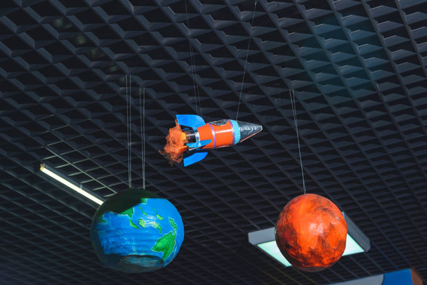 Plastic models of the planets of the solar system. The layouts of the planets hang against the black ceiling. Children's holiday. - Photo, Image