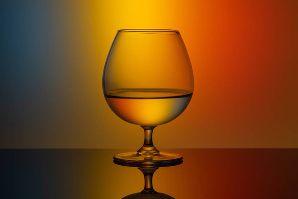 Jedna skleněná sklenice vody na různobarevné pozadí - Fotografie, Obrázek