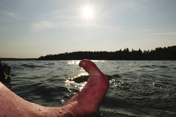 Sztokholm, Szwecja stopy zwisające w wodzie. - Zdjęcie, obraz